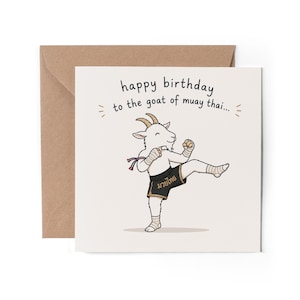 May include: A square greeting card featuring a cartoon goat performing a Muay Thai kick. The goat wears black shorts with gold text and hand wraps. The text reads: happy birthday to the goat of muay thai... The card is paired with a brown envelope.
