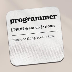 May include: Square white coaster featuring the word "programmer" in a bold, black font. The definition includes pronunciation and the phrase "fixes one thing, breaks two." The background has a subtle binary code pattern.