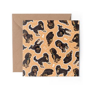 May include: A card featuring a repeating pattern of black and brown doodle dogs on a light orange background.
