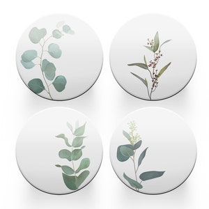 May include: Set of four round coasters featuring different watercolour illustrations of eucalyptus leaves and branches on a white background.