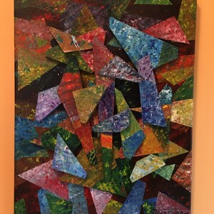 May include: Abstract painting on canvas with a colorful geometric design of overlapping triangles in shades of red, blue, green, purple, and brown. The artist's signature "Stempien" is in the bottom right corner.
