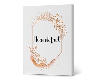 May include: A white canvas print with a gold hexagonal frame and floral design. The text "Thankful" is written in black inside the frame.