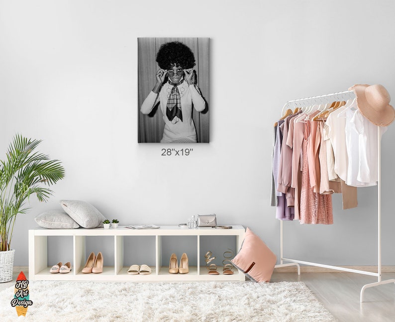 Może przedstawiać: Czarno-biały wydruk fotograficzny kobiety w białej koszuli z czarno-białym wzorzystym szalem i dużymi okularami. Zdjęcie jest oprawione i ma wymiary 71,1 cm x 48,3 cm.