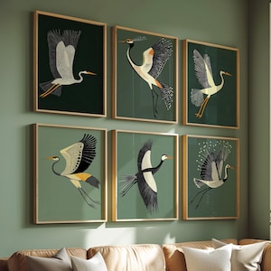 May include: Six framed art prints depicting stylized cranes in flight. Each print shows a different crane design with black, white, and yellow details against a dark green backdrop. The frames have a gold finish.