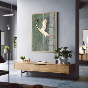 May include: A framed illustration of a stylized crane with a long neck and a spread of feathers. The crane is depicted in shades of orange, black, and white against a green background.