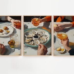Pu&ograve; includere: Set di tre stampe artistiche incorniciate raffiguranti una scena di ristorazione. L'opera mostra mani che tengono bevande e piatti di cibo, tra cui ostriche, limoni e pasticcini. La tavolozza dei colori &egrave; calda, con arancioni, bianchi e blu.