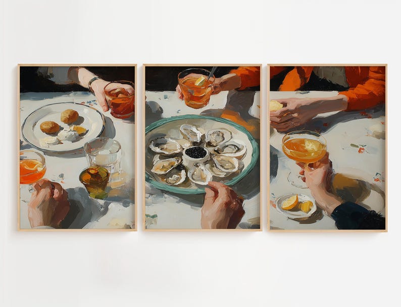 Pu&ograve; includere: Set di tre stampe artistiche incorniciate raffiguranti una scena di ristorazione. L'opera mostra mani che tengono bevande e piatti di cibo, tra cui ostriche, limoni e pasticcini. La tavolozza dei colori &egrave; calda, con arancioni, bianchi e blu.