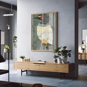 May include: A framed illustration of a bird with black, white, yellow, and blue feathers. The bird has a red eye and is standing on a branch. The background is a green and brown forest.