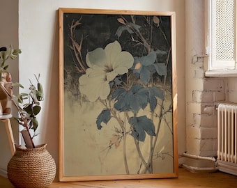 May include: A framed botanical print showing a large white flower and blue-green leaves against a dark background. The artwork is in a wooden frame and rests on a wooden floor. The style is reminiscent of vintage botanical illustrations.