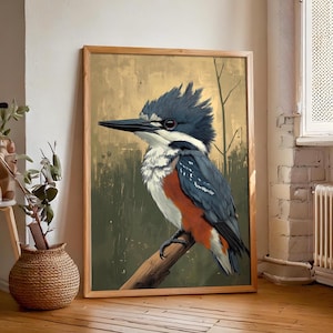 Puede incluir: Una impresión artística enmarcada que presenta una ilustración detallada de un martín pescador posado en una rama. El ave tiene plumaje azul, blanco y naranja, con un largo pico negro. El fondo tiene una paleta de colores verde y dorado apagados.