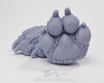 May include: A light gray, detailed paw pad sculpture with visible claws and fur. The sculpture features five rounded toe pads and a larger central pad. The text "CREATURECAVE.co.uk" is visible at the bottom.