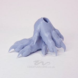 May include: Two gray 3D printed plastic claws with detailed textured fur and sharp claws. The claws are designed to be attached to a larger object.