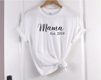 May include: White t-shirt with black text that reads "Mama Est. 2019".