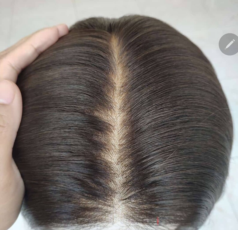 May include: Close-up of a dark brown human hair wig with a lace front. The hair is parted in the middle and styled in a straight, sleek look.