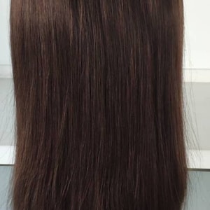 May include: A long, straight, dark brown wig on a mannequin head.