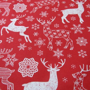 May include: Red fabric with a repeating pattern of white reindeer and snowflakes. The reindeer are in various poses, some with intricate patterns within their silhouettes. The snowflakes vary in size and design, creating a festive holiday theme.