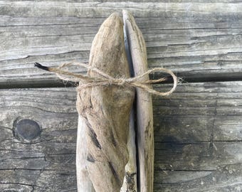 Peut inclure: Un lot de trois morceaux de bois flotté liés ensemble avec de la ficelle. Le bois flotté est de couleur brun clair et gris et a un aspect naturel et vieilli.