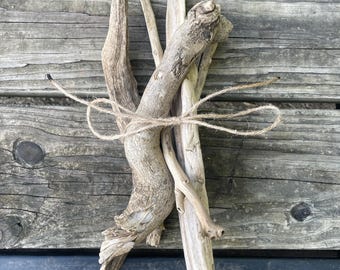 Peut inclure: Trois morceaux de bois flotté liés ensemble avec de la ficelle. Le bois flotté est brun clair et a un aspect naturel et vieilli.