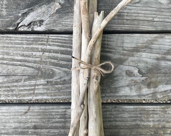 Peut inclure: Un lot de branches de bois flotté liées ensemble avec de la ficelle. Les branches sont de différentes tailles et formes, et ont un aspect naturel et vieilli.