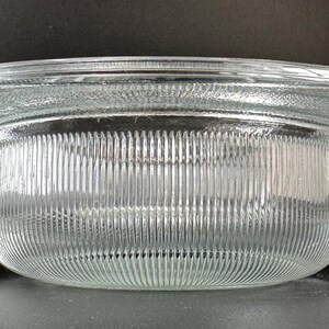May include: A clear glass bowl with a wide, flat rim and a fluted, textured interior. The bowl is designed for decorative purposes.
