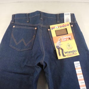 May include: Blue denim jeans with a Wrangler label and a Pro Rodeo Cowboy Cut tag. The jeans have a classic five-pocket style and a straight leg.