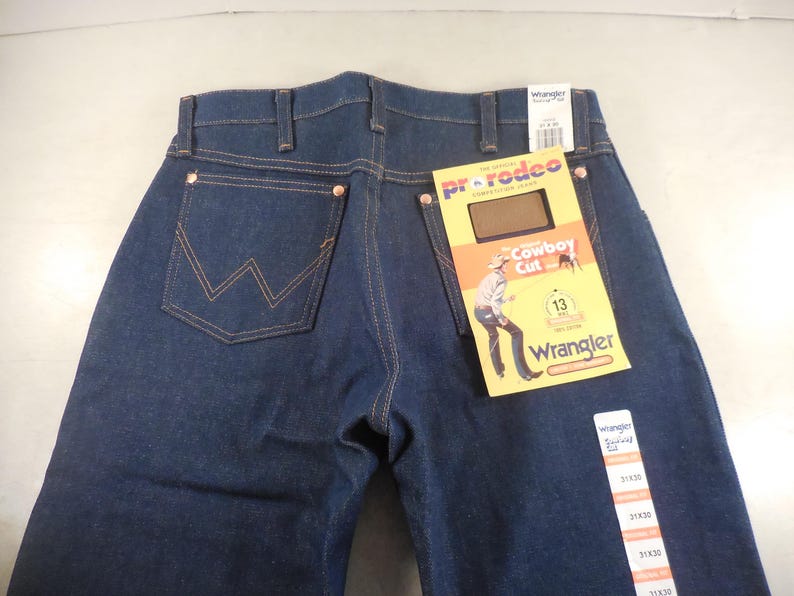 May include: Blue denim jeans with a Wrangler label and a Pro Rodeo Cowboy Cut tag. The jeans have a classic five-pocket style and a straight leg.