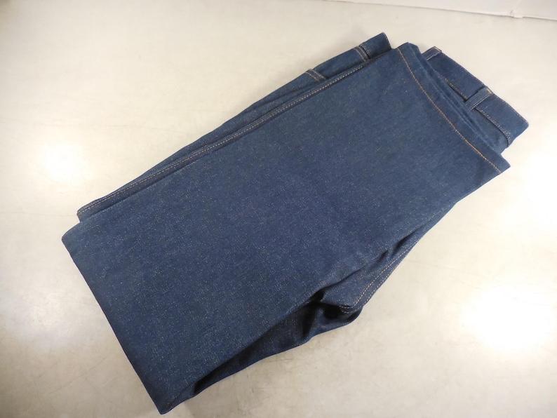 May include: A pair of folded blue denim jeans.