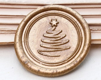 May include: A gold wax seal with a stylized image of a Christmas tree with a star on top.