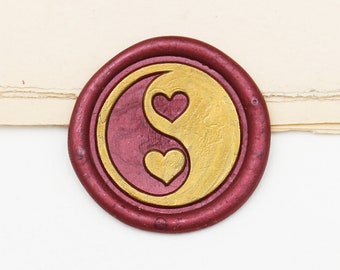 May include: A red wax seal with a gold yin yang symbol and two hearts inside.