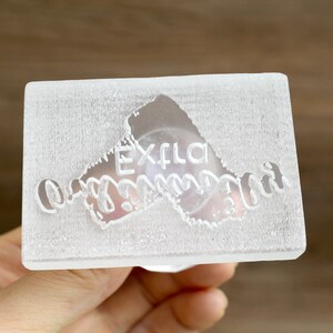 May include: A clear acrylic stamp with the text "Extra Ordinary" in a cursive font.