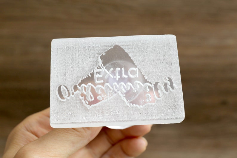 May include: A clear acrylic stamp with the text "Extra Ordinary" in a cursive font.