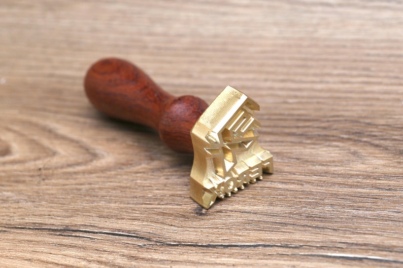 May include: A wooden handled brass stamp with the word "MONEY" embossed on the face.