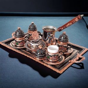 Op de afbeelding: Een traditionele Turkse koffie set met een koperen dienblad, pot, kopjes en schoteltjes. De set heeft ingewikkelde handgeschilderde bloemmotieven in levendige kleuren.