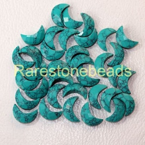 May include: A collection of turquoise crescent moon shaped beads. The beads are made of natural turquoise and have a mottled pattern.