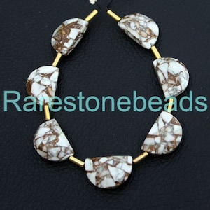May include: A strand of white and brown gemstone beads with gold spacers. The beads are half-round and have a marbled pattern.