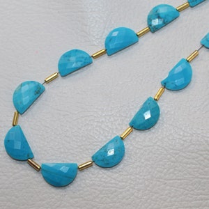 May include: A strand of turquoise gemstone beads, each bead is a half-circle shape with a faceted finish. The beads are strung on a wire with gold-colored spacers between each bead.