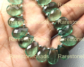May include: A strand of green gemstone beads in a teardrop shape. The beads are strung on silver wire.