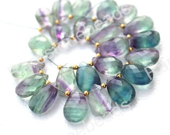May include: A strand of green, blue, and purple fluorite gemstone beads with gold spacers. The beads are faceted and have a teardrop shape.