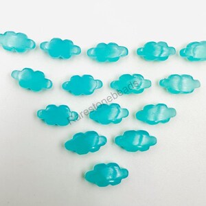 May include: A collection of 15 turquoise blue cloud shaped glass beads. The beads are arranged in a triangular pattern on a white background.
