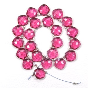 Puede incluir: Una hebra de cuentas de piedras preciosas facetadas de color rosa. Las cuentas están enhebradas en un alambre de plata con pequeñas cuentas de plata entre cada cuenta de piedra preciosa.