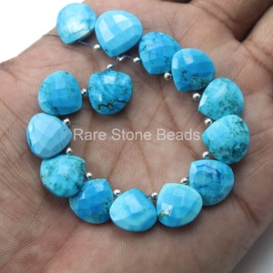 Puede incluir: Un collar de cuentas de turquesa en forma de corazón con superficies facetadas y espaciadores plateados. Las cuentas son de un color azul verdoso vibrante, con vetas naturales. El texto "Rare Stone Beads" es visible.