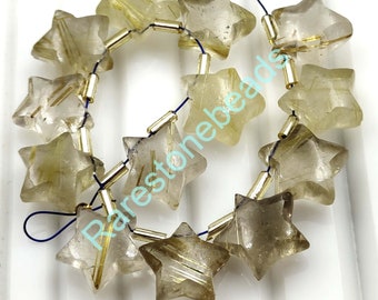 Può includere: Una collana di 12 perle a forma di stella in quarzo rutilato dorato. Le perle sono sfaccettate e hanno un colore traslucido marrone chiaro con inclusioni dorate. Le perle sono infilate su un cordoncino blu con anelli di giunzione dorati.