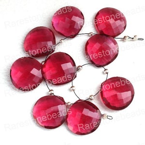 May include: A strand of faceted, round, pink gemstone beads. The beads are strung on a silver wire with silver spacer beads.