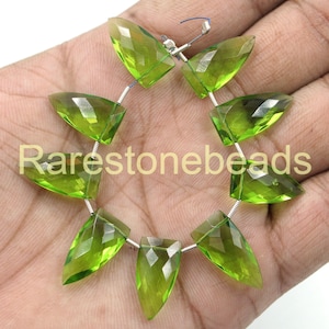 Peut inclure: Un brin de perles de pierres précieuses vertes, chaque perle est facetée et en forme de pointe acérée. Les perles sont enfilées sur un fil d'argent.