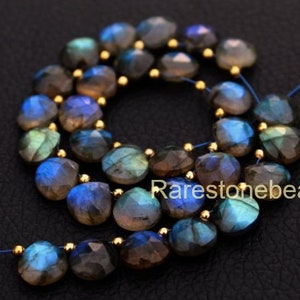 Peut inclure: Un collier de perles de labradorite bleu et vert irisé. Les perles sont facettées et ont une finition lisse et polie. Les perles sont enfilées sur un fil fin avec des entretoises dorées.