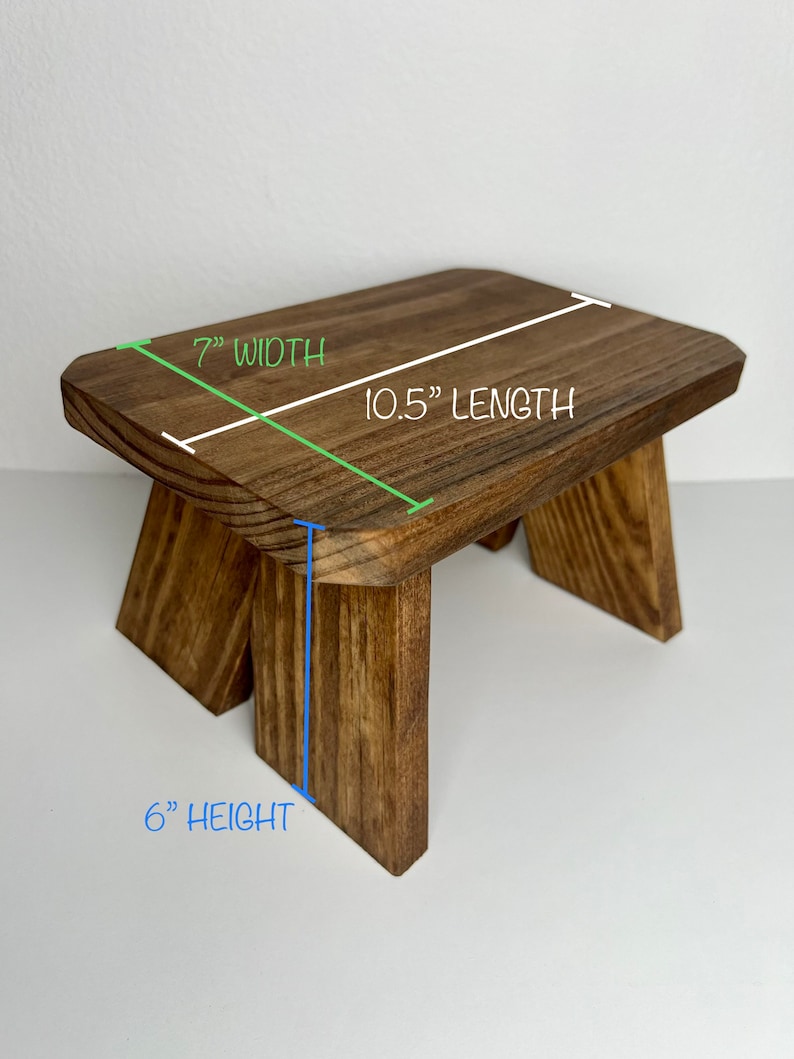 May include: A wooden step stool with a natural brown finish. The stool is 10.5 inches long, 7 inches wide, and 6 inches high.