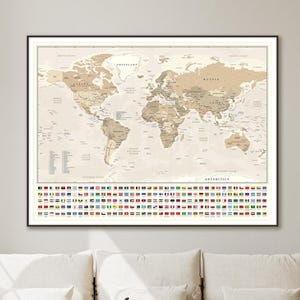 May include: Framed world map print in neutral tones, featuring detailed geographical information. The map includes country flags along the bottom and is displayed in a black frame. A decorative piece for home or office.