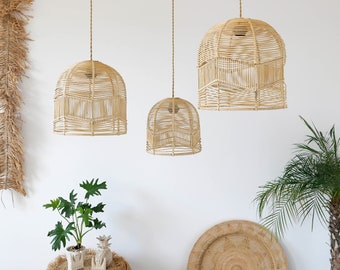 Pode incluir: Três luzes pendentes de vime tecidas penduradas no teto. As luzes são de tamanhos diferentes e têm uma cor bege natural.