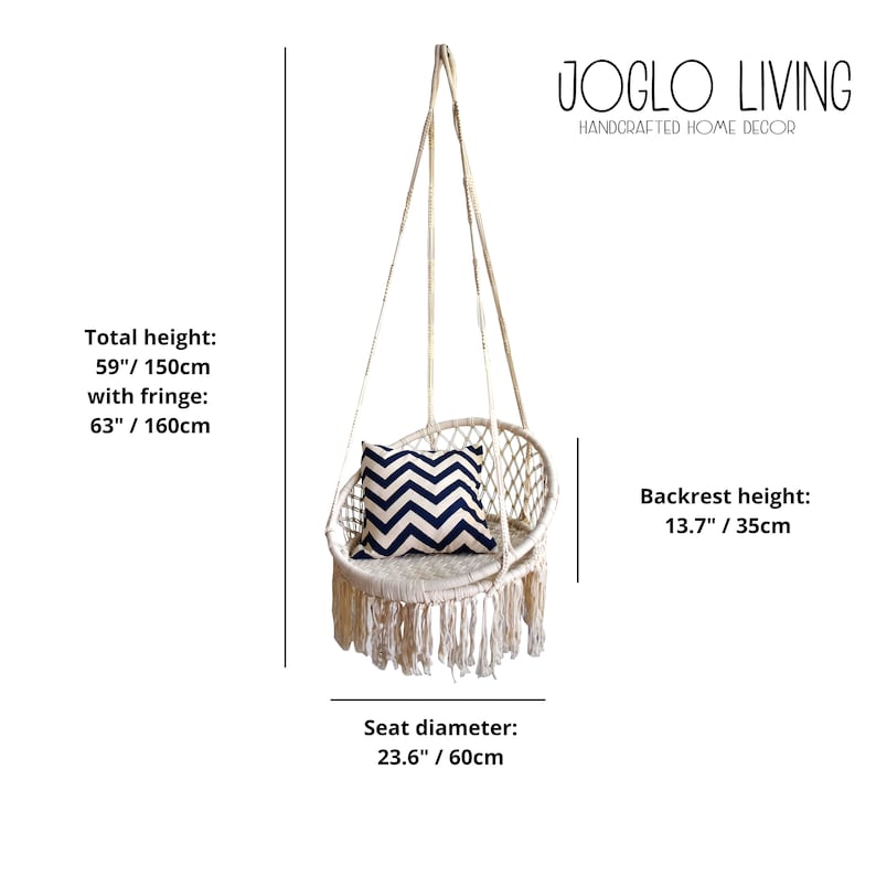 May include: White macrame hanging chair with fringe, a black and white chevron patterned pillow, and a white rope suspension system. The chair is 63 inches tall with fringe and has a 23.6 inch diameter seat. JOGLO LIVING HANDCRAFTED HOME DECOR is printed on the image.