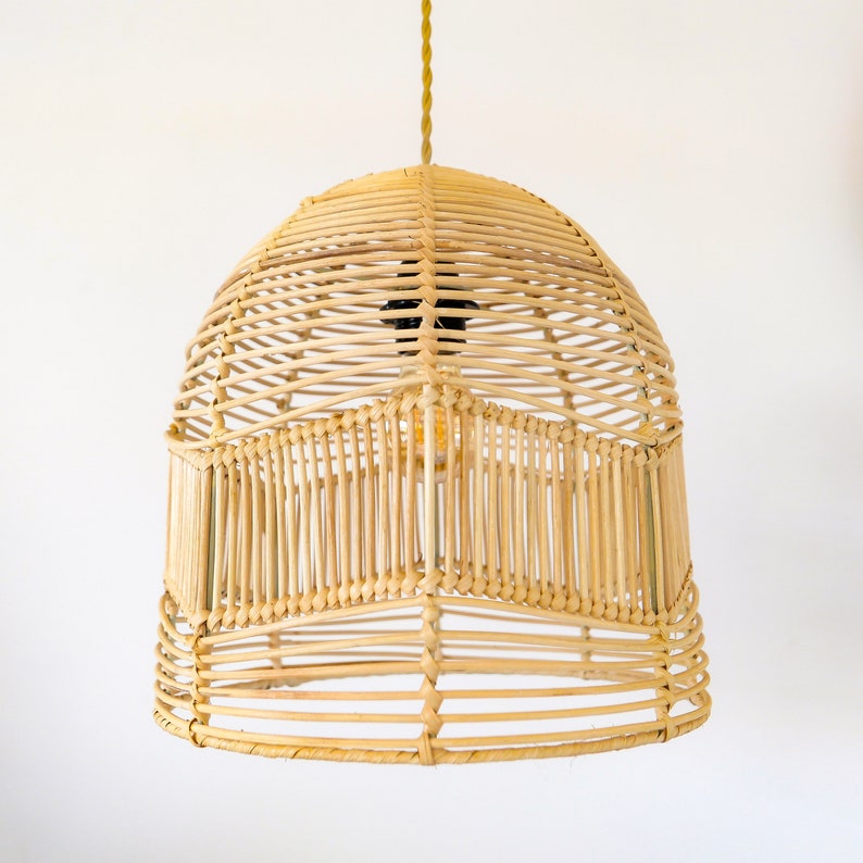 May include: A natural woven pendant light fixture with a dome shape. The light fixture is made of light brown rattan and has a woven pattern.